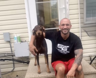 Illustration de l'article : Dévasté par la perte de son Dobermann, cet homme reçoit la présence d’un autre chien dans sa famille d’accueil comme un signe et décide de l’adopter