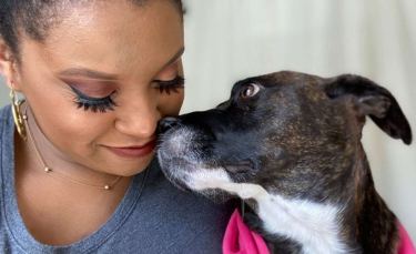 Illustration : "Une femme émue par le regard triste d’un chien maltraité par le passé, tente de lui apporter son aide"