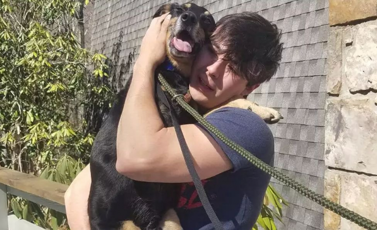 Illustration : "Un jeune homme heureux de serrer son chien à 3 pattes dans ses bras, après l'avoir cherché pendant 6 mois"