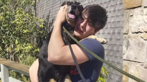 Illustration : Un jeune homme heureux de serrer son chien à 3 pattes dans ses bras, après l'avoir cherché pendant 6 mois