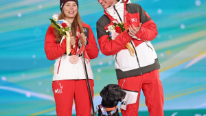 Illustration : "Jeux paralympiques : une skieuse de fond autrichienne gravit les marches du podium et offre une médaille à son chien guide (vidéo)"