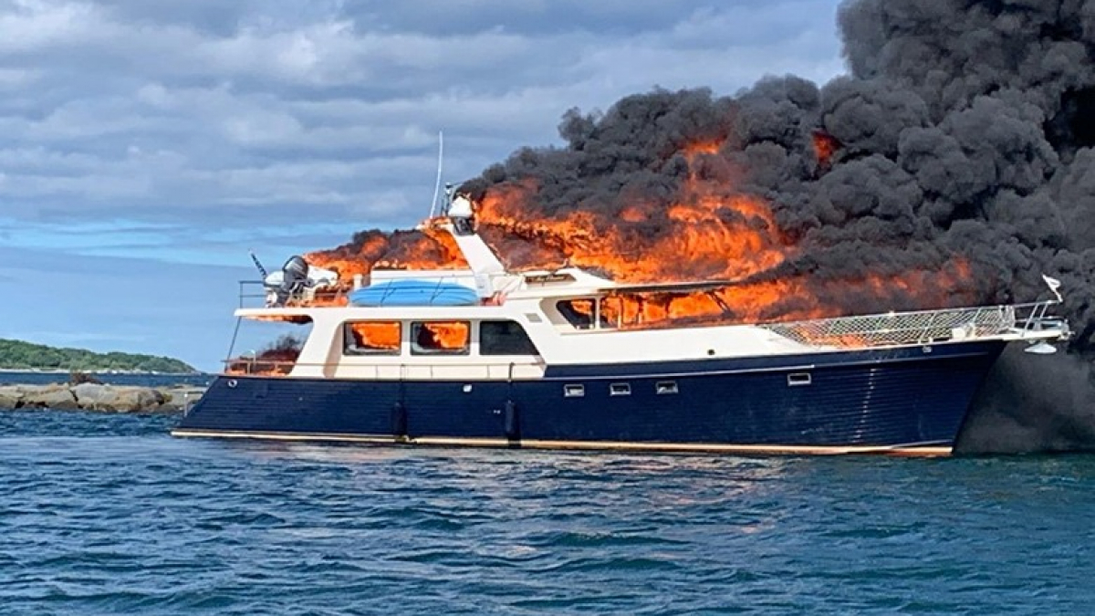 Illustration : "2 chiens et leurs maîtres bloqués sur leur bateau en flamme : ils sautent à l’eau pour s’échapper"
