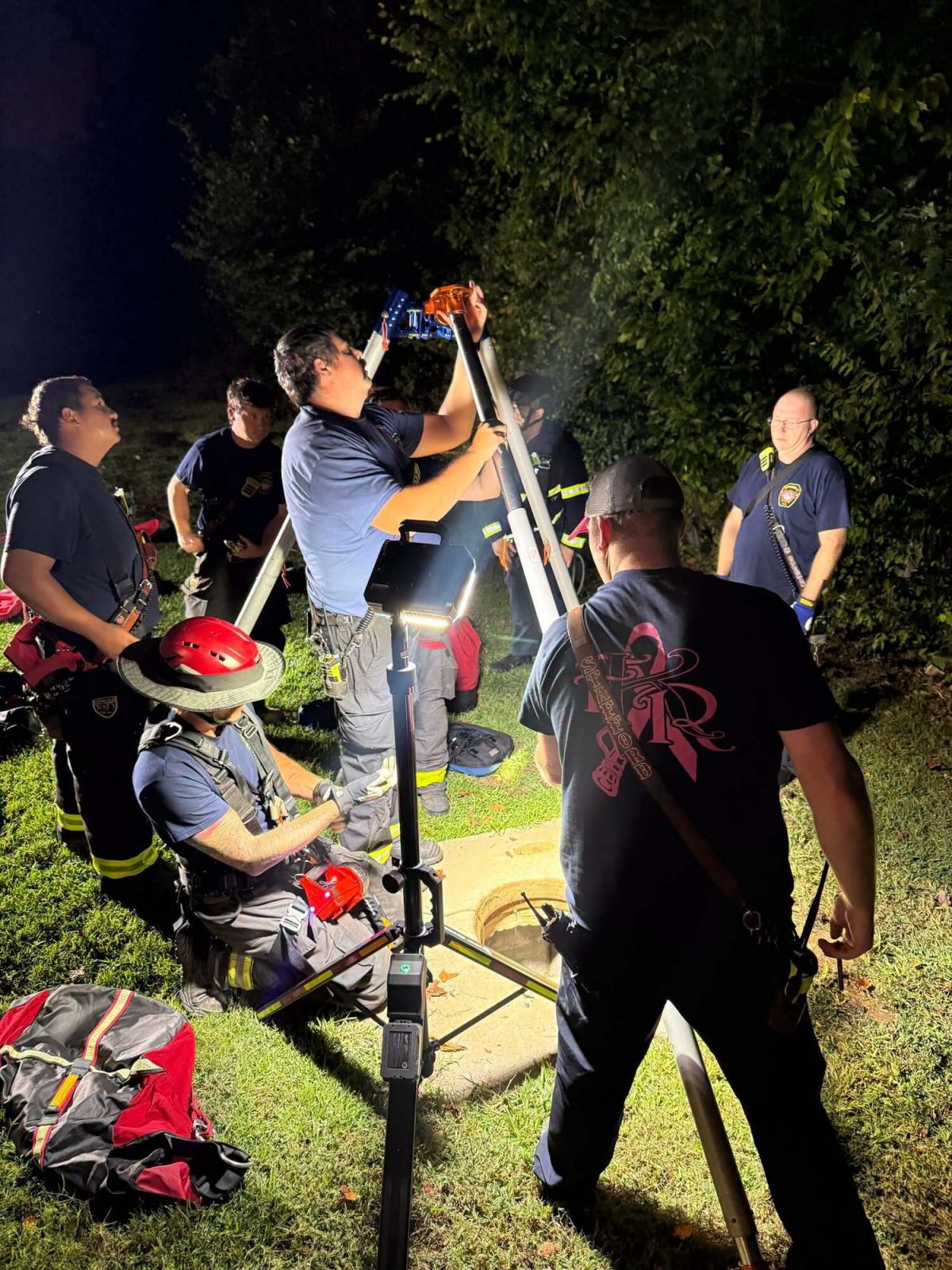 Les pompiers testant l'air dans la bouche d'égout et préparant leurs équipements