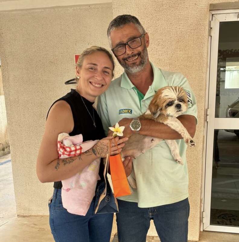 Un homme tient Jasmin dans ses bras aux côtés d'une femme souriante