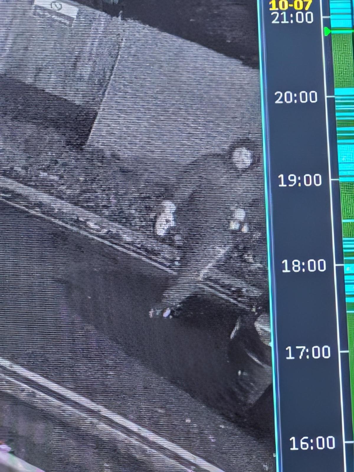 Image de vidéosurveillance nocturne montrant une silhouette sombre près d'un muret